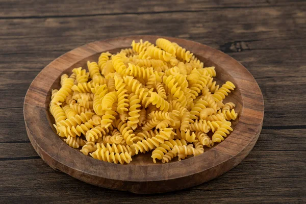 Wooden Plate Uncooked Fusilli Pasta Wooden Surface High Quality Photo — Stock Photo, Image