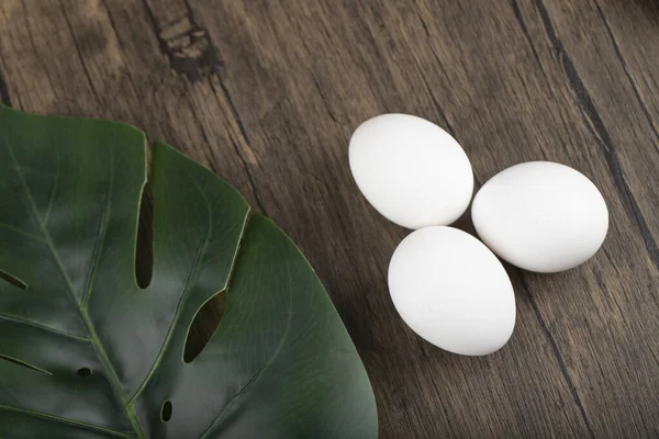 Τρία Φρέσκα Αυγά Πράσινο Φύλλο Ξύλινο Φόντο Υψηλής Ποιότητας Φωτογραφία — Φωτογραφία Αρχείου