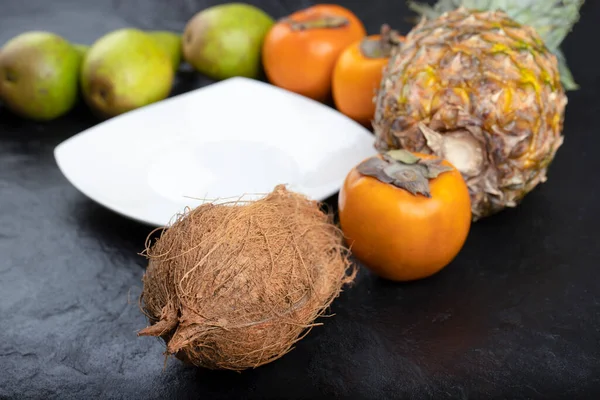 Ramo Frutas Exóticas Alrededor Plato Blanco Sobre Fondo Negro Foto —  Fotos de Stock