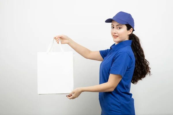 Hermosa Mensajera Femenina Traje Azul Mostrando Bolsas Blancas Foto Alta —  Fotos de Stock