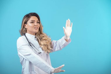 Beyaz üniformalı kadın bir şeyi durduruyor. Yüksek kalite fotoğraf