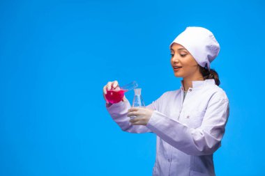 Beyaz üniformalı genç hemşire gülümseyerek test yapıyor. Yüksek kalite fotoğraf