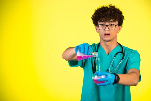 Lockiges Haar Junge Medizinischer Uniform Und Handmasken Die Rosa Flüssigkeit — Stockfoto