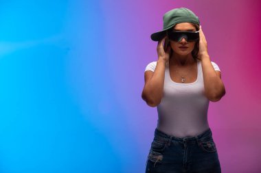 Yeşil şapkalı ve güneş gözlüklü sarışın bir manken ve gizemli görünüyor. Yüksek kalite fotoğraf