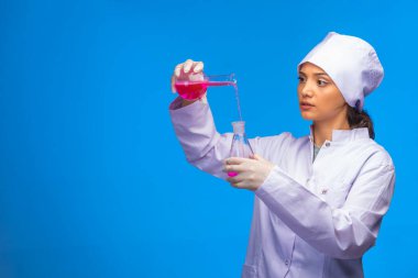 Genç hemşire kimyasal reaksiyonu çok dikkatli yapar. Yüksek kalite fotoğraf