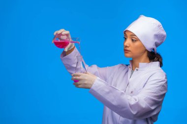 Genç hemşire profesyonel bir şekilde kimyasal reaksiyon gösteriyor. Yüksek kalite fotoğraf