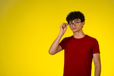 Kırmızı gömlekli adam gözlüklerine dokunuyor ve onlara bakıyor. Yüksek kalite fotoğraf