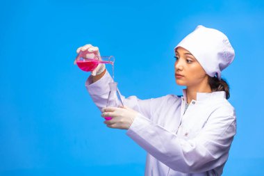 Genç hemşire kimyasal reaksiyonu dikkatli bir şekilde yapar. Yüksek kalite fotoğraf