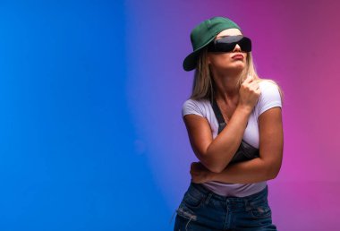 Yeşil şapkalı ve güneş gözlüklü sarışın kötü görünüyor. Yüksek kalite fotoğraf