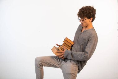 Kıvırcık saçlı, iyimser gözlüklü çocuk neredeyse ağır kitaplar düşürüyordu. Yüksek kalite fotoğraf