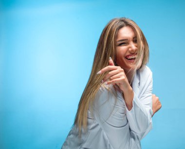 Beyaz gömlekli sarışın model baştan çıkarıcı görünüyor ve gülümsüyor. Yüksek kalite fotoğraf