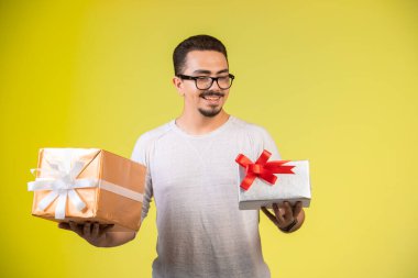 Elinde iki hediye kutusu olan ve gülümseyen bir adam. Yüksek kalite fotoğraf