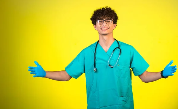 Lockenkopf Junge Arztuniform Und Handmasken Begrüßt Patienten Hochwertiges Foto — Stockfoto