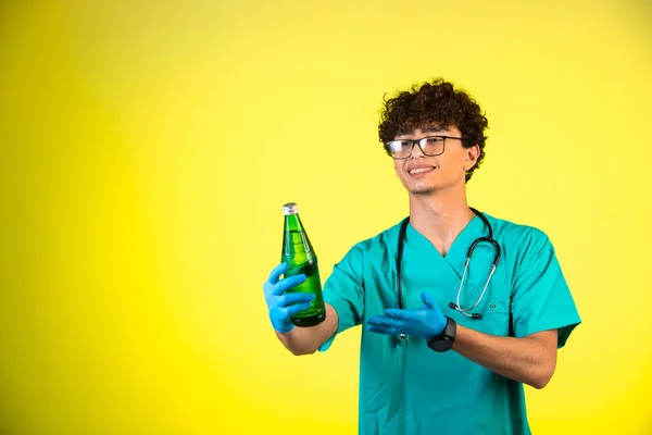 Lockiger Junge Medizinischer Uniform Und Hand Die Eine Flasche Flüssigkeit — Stockfoto