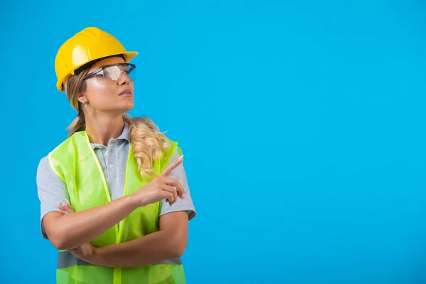 Ingenieurinnen Gelbem Helm Und Schutzkleidung Tragen Schutzbrillen Und Zeigen Etwas — Stockfoto