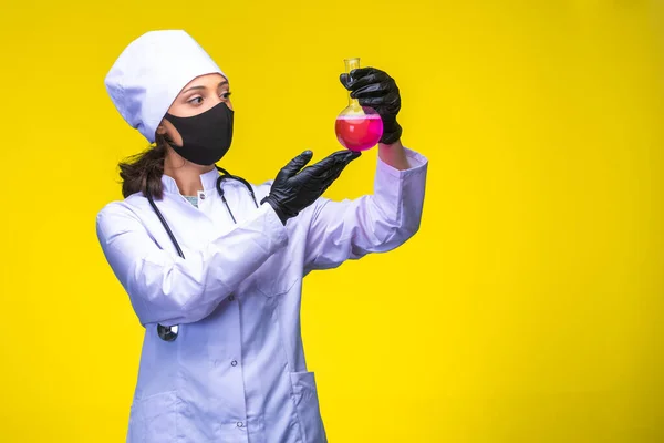 Young Nurse Face Hand Mask Holds Chemical Flask Yellow Background — Stock Photo, Image