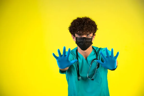 Capelli Ricci Ragazzo Uniforme Medica Maschera Viso Mostrando Mani Foto — Foto Stock