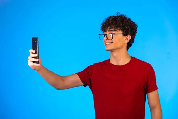 Kırmızı Tişörtlü Bir Adam Selfie Çekiyor Telefon Edip Kameraya Gülümsüyor — Stok fotoğraf