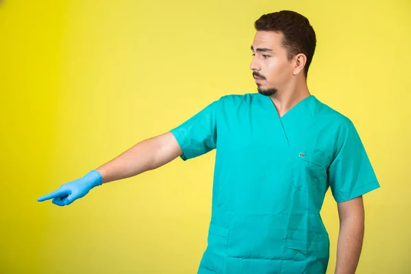 Arzt Uniform Und Handmaske Zeigt Etwas Zur Seite Hochwertiges Foto — Stockfoto