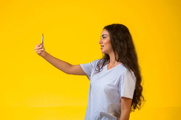 Junges Mädchen Beim Selfie Mit Dem Handy Auf Gelbem Hintergrund — Stockfoto