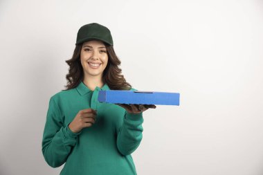 Elinde pizza kutusu olan yeşil üniformalı bir teslimatçı kadın. Yüksek kalite fotoğraf