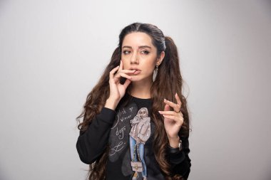 Parmak izi eşofmanlı genç kız gri arka planı derin düşünüyor. Yüksek kalite fotoğraf