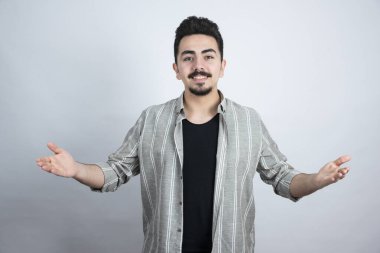 Beyaz duvarın üzerinde mutlu hisseden sakallı bir adamın portresi. Yüksek kalite fotoğraf