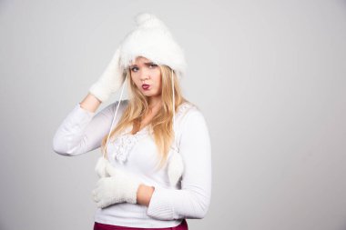 Beyaz şapkalı ve beyaz kazaklı güzel bir kadın. Yüksek kalite fotoğraf