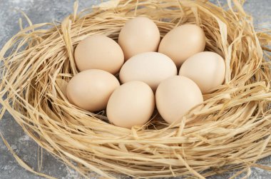 Mermer yüzeyinde kuş yuvası olan çiğ yumurtalar. Yüksek kalite fotoğraf