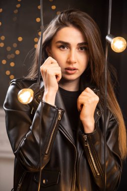 Lambaların yanında poz veren siyah deri ceketli güzel bir mankenin portresi. Yüksek kalite fotoğraf