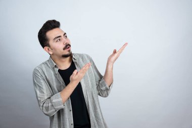 Beyaz duvarın arkasında bir yere bakan sakallı adamın portresi. Yüksek kalite fotoğraf