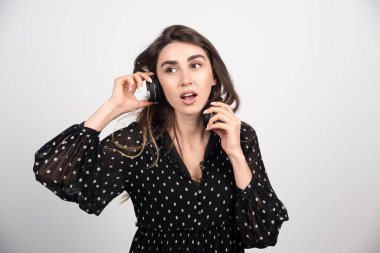 Kulaklıkla müzik dinleyen genç bir bayan model beyaz bir arka planda. Yüksek kalite fotoğraf