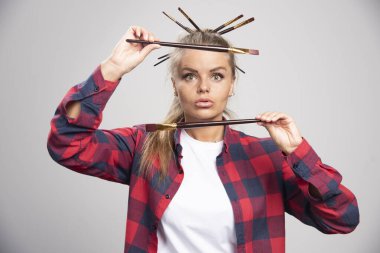 Sarışın sanatçı fırçalarının arasından bakıyor. Yüksek kalite fotoğraf