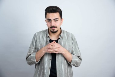 Beyaz duvarın üzerinde sıradan giyinmiş genç bir adamın fotoğrafı. Yüksek kalite fotoğraf