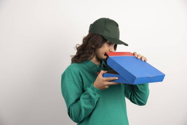Aç teslimatçı kadın beyaz arka planda pizza kutusu açıyor. Yüksek kalite fotoğraf