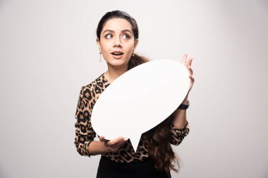 Leopar desenli tişörtlü iş kadını elinde yuvarlak bir düşünce tahtası tutuyor. Yüksek kalite fotoğraf