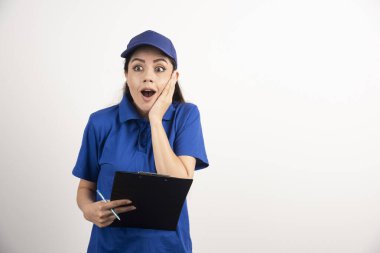 Beyaz arka planda profesyonel teslimatçı kadın şok oldu. Yüksek kalite fotoğraf