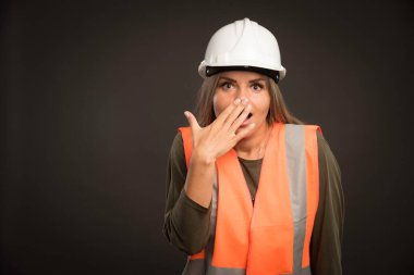 Kadın mühendis beyaz kask ve teçhizat takıyor ve şaşırmış görünüyor. Yüksek kalite fotoğraf