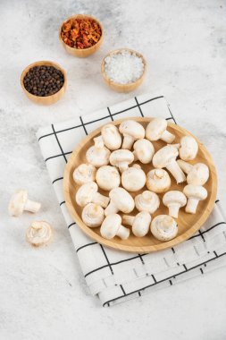 Çeşitli baharatlarla servis edilmiş ahşap bir tabakta mantarlar. Yüksek kalite fotoğraf