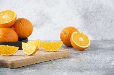 Taş zemin üzerinde portakal suyu dilimleriyle dolu tahta bir tahta. Yüksek kalite fotoğraf