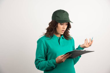 Dişi kurye, panoya şok edici bir şekilde bakıyor. Yüksek kalite fotoğraf