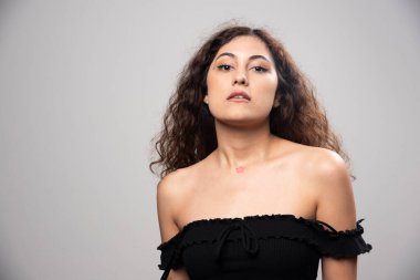 Siyah bluz giymiş kıvırcık saçlı genç bir kadın. Yüksek kalite fotoğraf