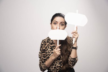 Leopar desenli tişörtlü kız elinde iki boş bilgi ya da yer tahtası tutuyor. Yüksek kalite fotoğraf