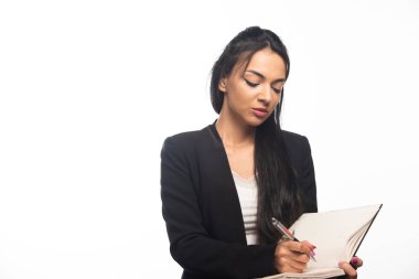 Not defterine kalemle yazan genç iş kadınının portresi. Yüksek kalite fotoğraf