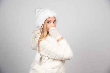 Gri arka planda poz veren kışlık ceketli genç bir kadın. Yüksek kalite fotoğraf