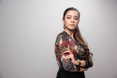 Gri arka planda duran renkli bluzlu genç kadın. Yüksek kalite fotoğraf