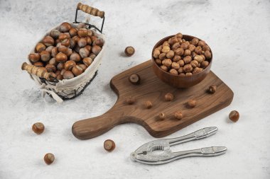 Bir sepet kabuklu fındık, çekirdek ve fındık kırma aleti kesme tahtasının yanında. Yüksek kalite fotoğraf
