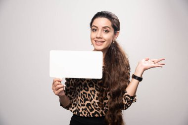 Leopar desenli tişörtlü iş kadını elinde dikdörtgen şeklinde bir bilgi panosu tutuyor. Yüksek kalite fotoğraf