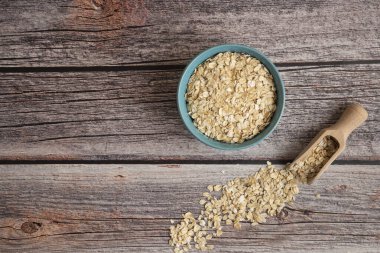 Tahta arka planda bir kasede yulaf ezmesi. en üstteki görünüm.