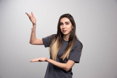 Gülümseyen kadın elini gösteriyor ve poz veriyor. Yüksek kalite fotoğraf